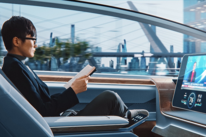 Man reading in a self driving car of the future